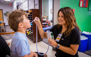 Nurse checking a students temperature 